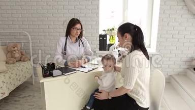 儿科女医生与幼儿及母亲就诊时谈话